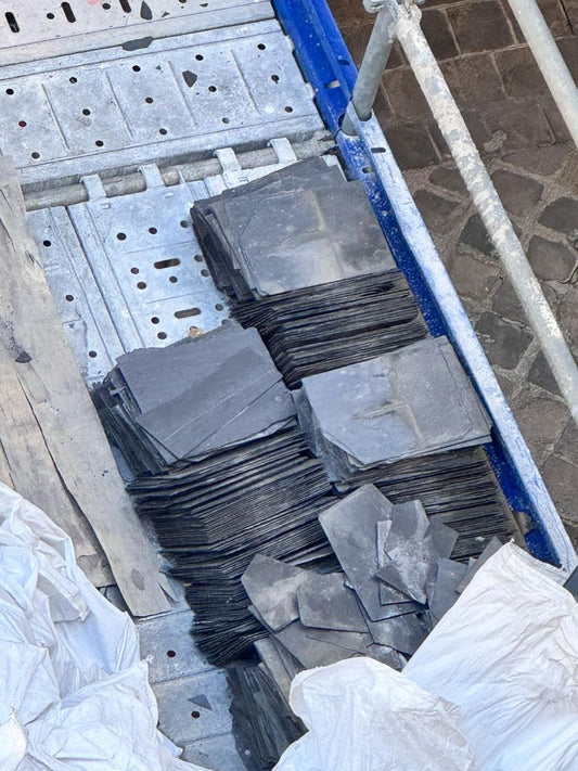 Ardoises naturelles de reemploi empilees sur un chantier de couverture